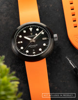 Mannar wristwatch with FKM Sundarban Orange Dawn strap and strap pin remover in a flat lay.