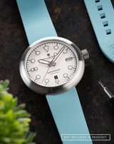 Zanskar wristwatch with FKM Nicobar blue strap and strap pin remover in a flat lay.