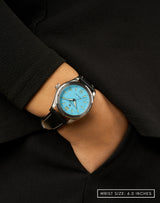 Woman wearing Men in Blue wristwatch, hand in pocket, featuring the sleek blue dial.