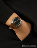 Pavilion watch on a woman's wrist, hand in pocket, featuring the sleek matte-black dial.