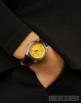 Woman wearing Yellow Jersey watch, hand in pocket, highlighting its vibrant yellow dial and sporty design.