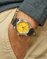 Man with hand in pocket, wearing Yellow Jersey watch, featuring the bright yellow dial and durable stainless steel case.