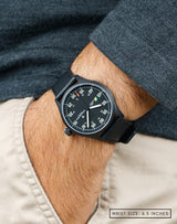 Man wearing MACH 1 Aviator Stealth Fighter wristwatch with hand in pocket, showing off its stealthy design.