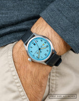 Man wearing MACH 1 Officer's Blue wristwatch with hand in pocket, highlighting the striking blue dial and sleek design.