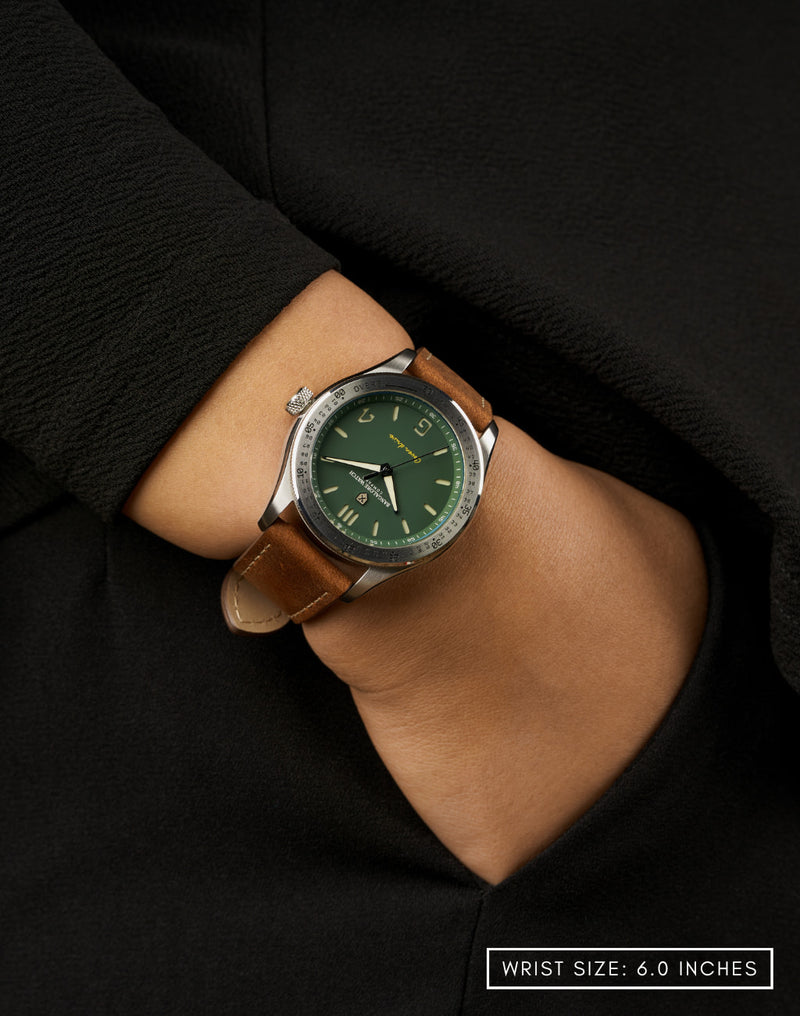 Woman wearing the Outfield watch with hand in pocket, highlighting its matte green dial and cricket-inspired style.