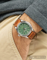 Man wearing the Outfield wristwatch with hand in pocket, highlighting the green dial and sleek stainless steel case.