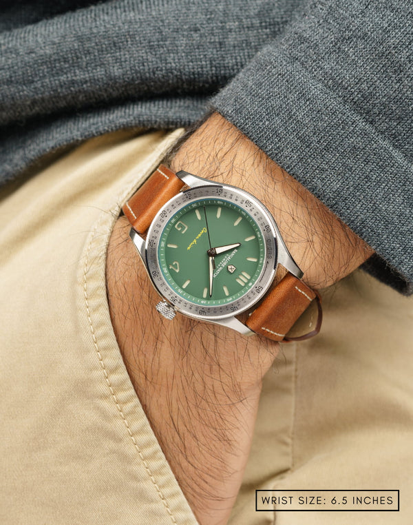 Man wearing the Outfield wristwatch with hand in pocket, highlighting the green dial and sleek stainless steel case.
