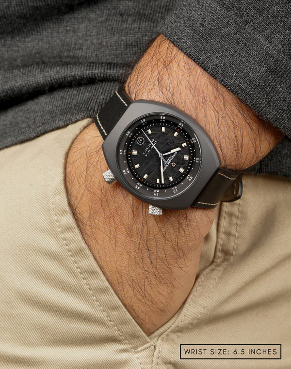 Man wearing Apogee Visitor on wrist, highlighting the 4.5 billion-year-old Muonionalusta meteorite dial in a Cerasteel™ case.