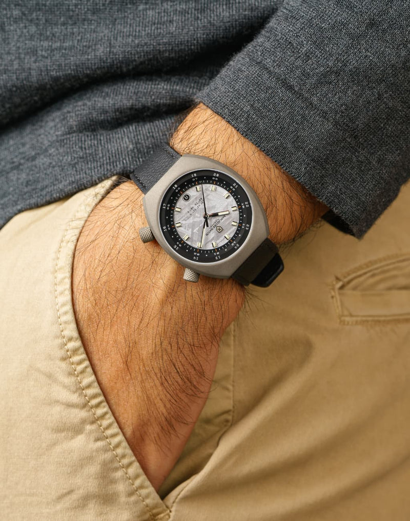 Man wearing Apogee Extraterrestrial wristwatch, hand in pocket, showcasing the unique Muonionalusta meteorite dial.